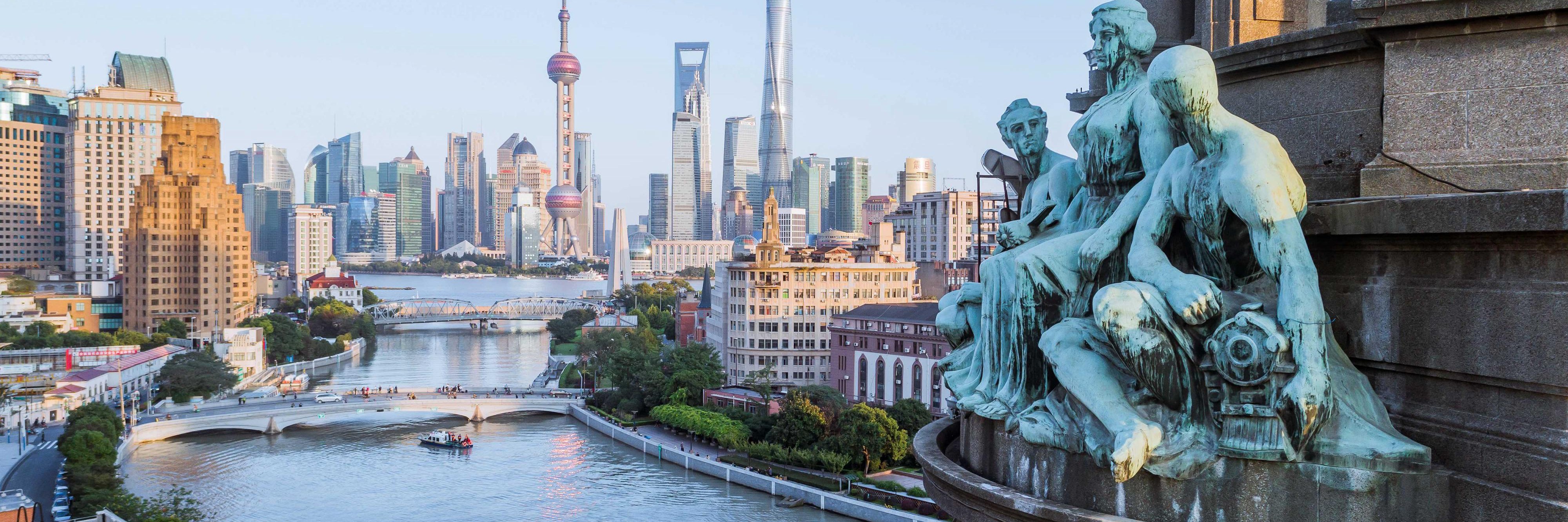 Photo of Suzhou Creek with bridges and the skyline beyond