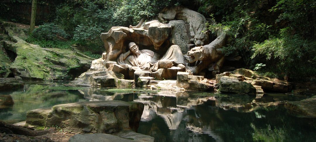 The Dreaming of the Tiger stone sculpture group at Hupao Spring, reflected in the pool in front of it
