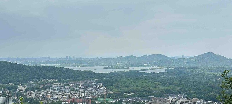 Panoramic view of West Lake from the Majiawu viewing platform with the city skyline beyond