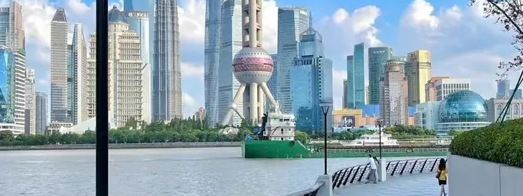 Photograph of the North Bund riverside greenway with the Shanghai skyline across the Huangpu
