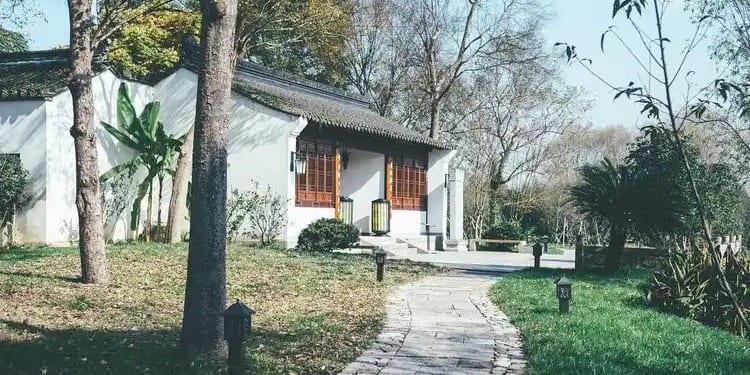 Traditional Ming dynasty courtyard garden with whitewashed walls and stone bridge at Hongzhong Bieye